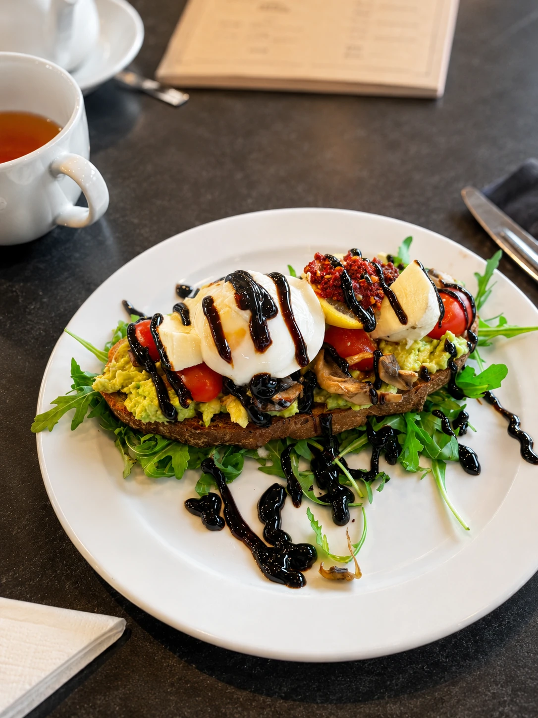 Avocado toast with egg, tomatoes and mushrooms